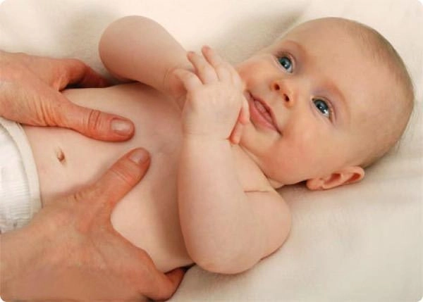 Foto einer sanften, osteopathischen Behandlung im Säuglingsalter – Therapeutin hält ein entspannt liegendes Baby und ertastet behutsam Blockaden im Nackenbereich